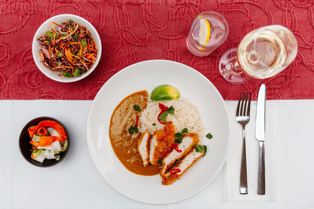 an aerial view of a table setting featuring Katsu curry with Asian slaw, perfect for using up Christmas leftovers